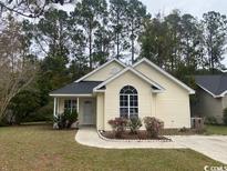 Cute yellow house with a landscaped yard and driveway at 3178 Red Bird Ln., Myrtle Beach, SC 29588