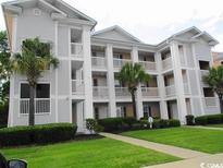 Three-story building with light gray siding, white columns, and palm trees at 617 Waterway Village Blvd. # 6-E, Myrtle Beach, SC 29579