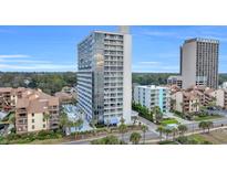 Aerial view of a high-rise building with a pool and surrounding landscape at 5511 N Ocean Blvd. # 203, Myrtle Beach, SC 29577