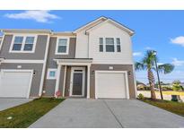 Two-story townhome with gray and white siding, two-car garage, and landscaping at 237 Sandridgebury Dr. # 58, Little River, SC 29566