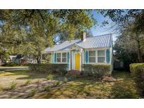 Charming light blue cottage with metal roof, landscaping, and yellow front door at 332 N Congdon St., Georgetown, SC 29440