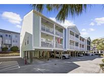 Two-story beach home with light green siding, balconies, and parking underneath at 209 North Hillside Dr. # 201, North Myrtle Beach, SC 29582