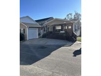 Tan house with a porch, dark brown steps, and attached garage at 6001-1774 S Kings Hwy., Myrtle Beach, SC 29575
