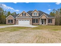 Brick and beige two-story house with a three-car garage and large yard at 3329 Hughes Gasque Rd., Aynor, SC 29511