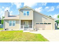 Beige two-story house with a two-car garage and well-maintained lawn at 611 Six Lakes Dr., Myrtle Beach, SC 29588