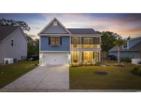 Two-story home with gray siding, front porch, and attached garage at 68 Grace Bay Ct., Pawleys Island, SC 29585