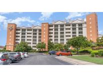 Exterior of a large, light-colored building with many windows and a parking lot at 8121 Amalfi Pl. # 4-1203 A&B, Myrtle Beach, SC 29572