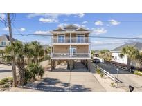Two-story home with elevated foundation, balconies, and a spacious driveway at 1050 Waccamaw Dr., Garden City Beach, SC 29576