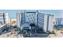 Aerial view of oceanfront high-rise building with parking and pool at 7100 N Ocean Blvd. # 424, Myrtle Beach, SC 29572