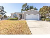 Charming single story home with attached garage and well-manicured lawn at 126 Lakeside Crossing Dr., Conway, SC 29526