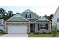 Two-story house with stone and shingle siding, a two-car garage, and landscaping at 6040 Forest Dell Ct, Myrtle Beach, SC 29579