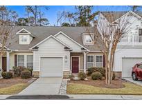 Attractive exterior of a two-story townhome with a garage and well-manicured landscaping at 230 Pilot House Pl. # 230, Carolina Shores, NC 28467