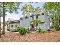 Two-story house with gray siding, red door, and landscaped yard at 406 Lafayette Rd., Myrtle Beach, SC 29572