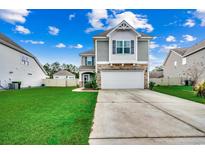 Two-story house with gray siding, stone accents, and a two-car garage at 5433 Merrywind Ct., Myrtle Beach, SC 29579