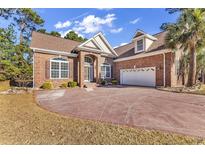 Brick home with a large driveway and landscaped lawn at 5603 Leatherleaf Dr., North Myrtle Beach, SC 29582