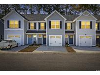 Three-unit townhome building, gray siding, two-car garages, and well-manicured landscaping at 608 Montenegro Way # E, Myrtle Beach, SC 29579