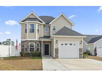 Two-story house with a gray roof, stone accents, and a two-car garage at 724 Hobonny Loop, Longs, SC 29568