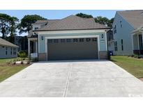 Charming two-story home with a two-car garage and landscaped yard at 1230 Crested Iris Way, North Myrtle Beach, SC 29582