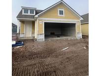 New construction home with a two-car garage and a yellow exterior at 1237 Crested Iris Way, North Myrtle Beach, SC 29582