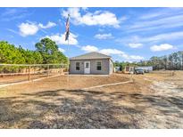 Gray single-story home with fenced yard and American flag displayed at 1744 Log Cabin Rd., Loris, SC 29569