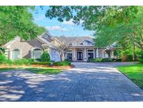 Elegant two-story home with brick and stone facade, paved driveway, and manicured landscaping at 604 Stableford Ct., Myrtle Beach, SC 29577