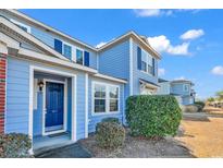 Two-story light blue townhome with navy blue front door and landscaping at 1857 Culbertson Ave. # 1857, Myrtle Beach, SC 29577