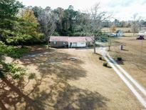 Red-roofed ranch home with large yard and long driveway at 3734 Highway 554, Loris, SC 29569