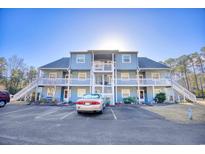 Front view of a two-story building with multiple units, ample parking, and landscaping at 24 Boundary Line Dr. Nw # C, Calabash, NC 28467