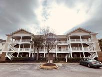 Inviting condo building exterior with ample parking and landscaping at 5751 Oyster Catcher Rd. # 633, North Myrtle Beach, SC 29582