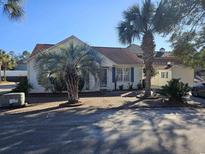 White house with palm trees and brick driveway at 927 Edge Dr., North Myrtle Beach, SC 29582