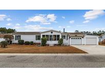 Single-wide manufactured home with attached garage and screened porch at 130 Tomoka Trail, Longs, SC 29568