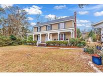 Two-story house with front porch, mature trees, and a spacious yard at 6011 Dick Pond Rd., Myrtle Beach, SC 29588