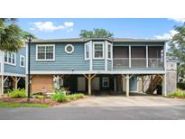 Elevated beach house with screened porch and parking underneath at 299 Lake Arrowhead Rd., Myrtle Beach, SC 29572