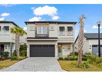 Two-story home with gray siding, dark garage door, and landscaping at 6723 Ocean Breeze Loop, Myrtle Beach, SC 29572