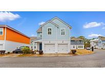 Two-story light blue house with a double garage and landscaping at 4739 Cloisters Ln., Myrtle Beach, SC 29577