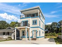Three-story house with blue accents, balcony, and off-street parking at 606 29Th Ave. S, North Myrtle Beach, SC 29582