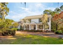 Two-story white house with a large front porch and landscaped yard at 356 Rossdhu Ave., Pawleys Island, SC 29585