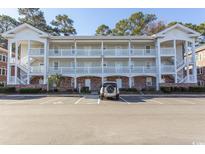 Two-story condo building with white exterior and ample parking at 690 Riverwalk Dr. # 201, Myrtle Beach, SC 29579