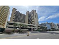 Oceanfront building, multiple stories, parking area, and palm trees at 501 S Ocean Blvd. # 601, North Myrtle Beach, SC 29582