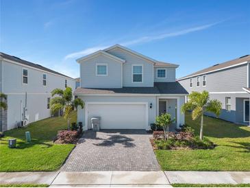 Two-story house with a gray exterior, gray driveway, and landscaping at 2201 Lelani Cir, Davenport, FL 33897