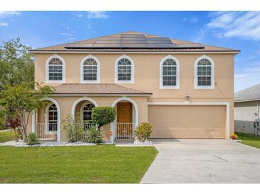 Two-story house with solar panels and arched windows at 11407 Bentry St, Orlando, FL 32824