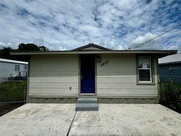 Updated bungalow exterior with new paint, landscaping, and a blue front door at 2808 Fletcher Ave, Lakeland, FL 33803