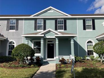 Two-story house with teal exterior, landscaping, and walkway at 516 Juniper Springs Dr, Groveland, FL 34736