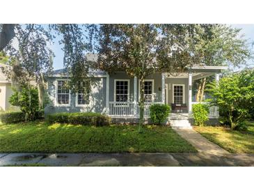 Gray house with white porch and landscaping at 7036 Mapperton Dr, Windermere, FL 34786