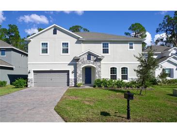 Two story house with gray siding and stone accents at 29912 Cypress Pointe, Deer Island, FL 32778