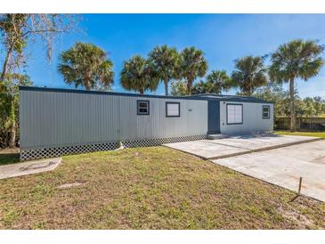 Mobile home exterior with grey siding, palm trees, and a paved driveway at 18925 3Rd Ave, Orlando, FL 32820