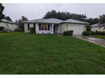 Single-story house with green lawn and attached garage at 6059 Magpie Dr, Lakeland, FL 33809