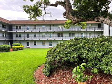 Two-story building with lush landscaping and a grassy lawn at 333 Lake Howard Nw Dr # 202C, Winter Haven, FL 33880