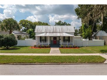 Charming craftsman home with a metal roof, red door, and landscaped yard at 815 E Church St, Bartow, FL 33830