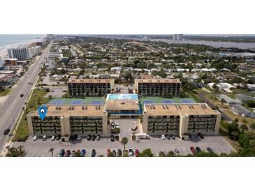 Aerial view of condo complex with tennis courts and pool at 1433 N Atlantic Ave # 422, Daytona Beach, FL 32118